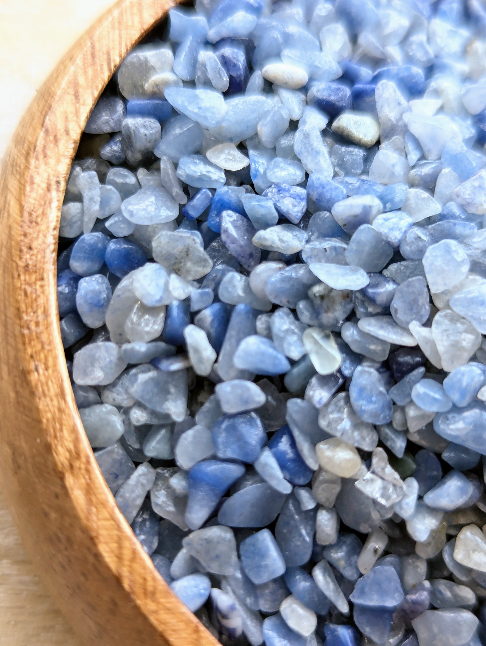 Close-up of blue aventurine chips in a wooden bowl