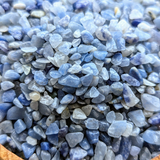Close-up of blue aventurine crystal chips in a wooden bowl