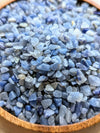 Close-up of blue aventurine crystal chips in a wooden bowl