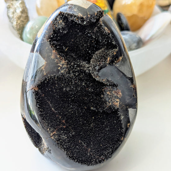 Dragon crystal egg on a white surface with blurred background