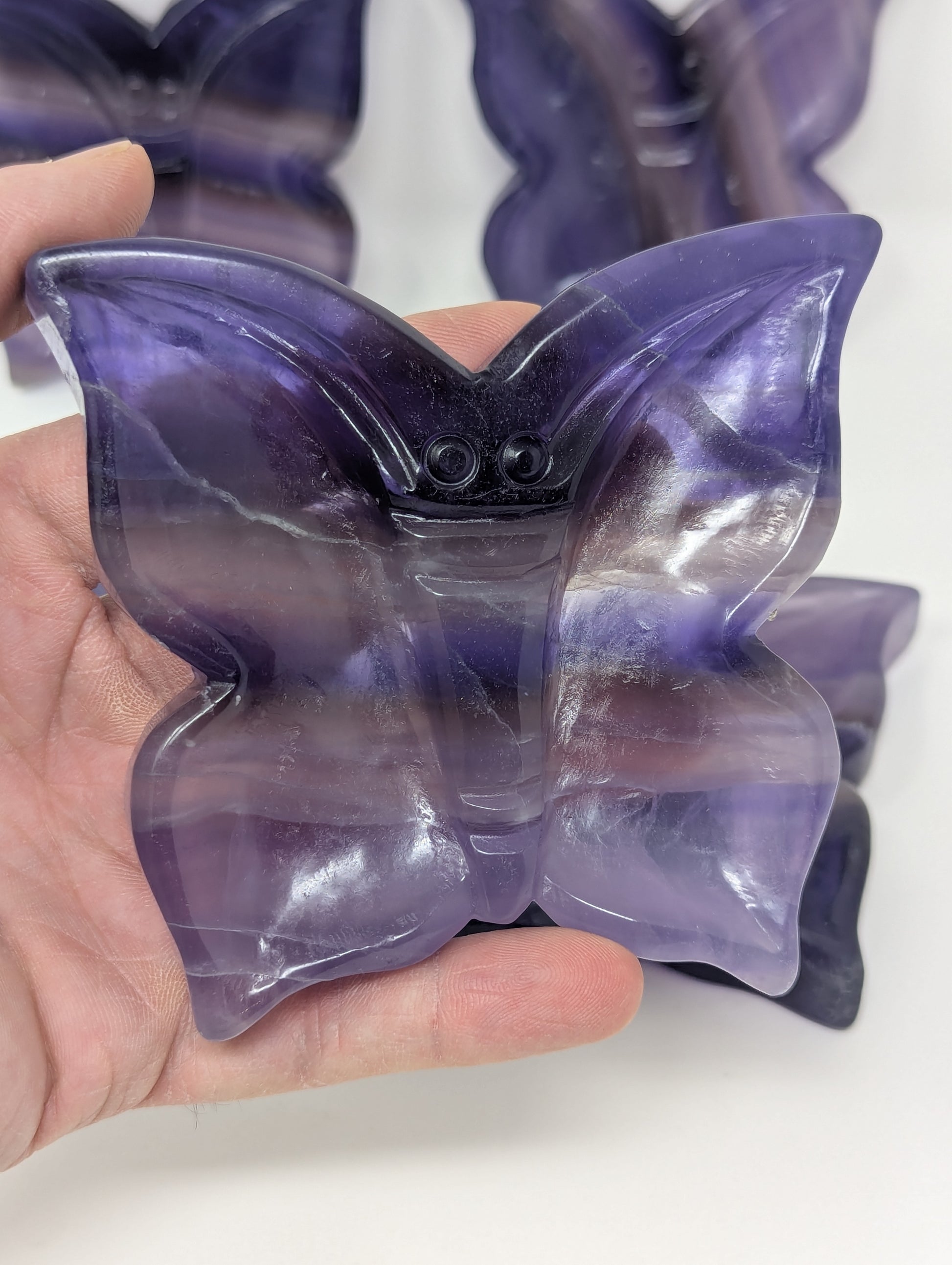 Purple butterfly-shaped gel pack held in a hand against a white background