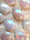Iridescent Angel Aura Rose Quartz Palm Stones stones on a wooden surface