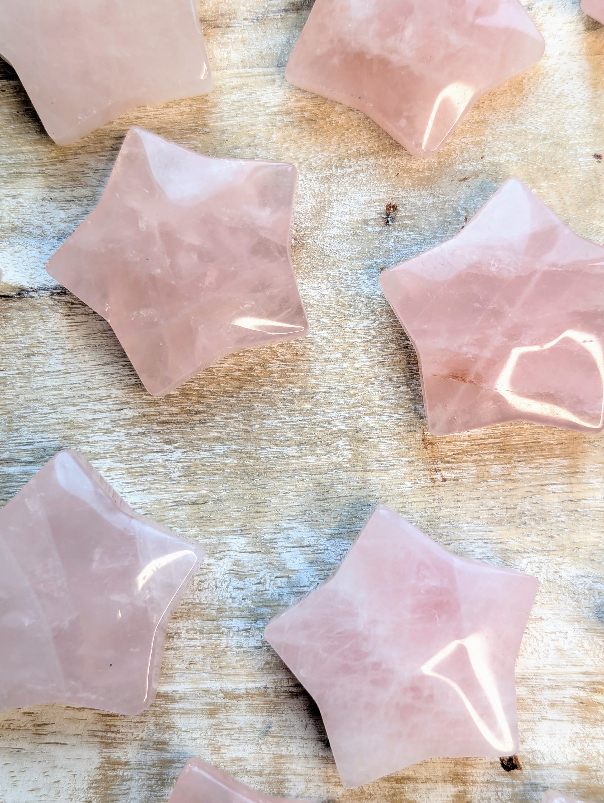 Rose quartz star carving pieces on a wooden surface