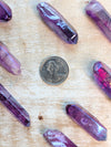 Angel Aura Purple crystal on a wooden surface with a coin for scale.