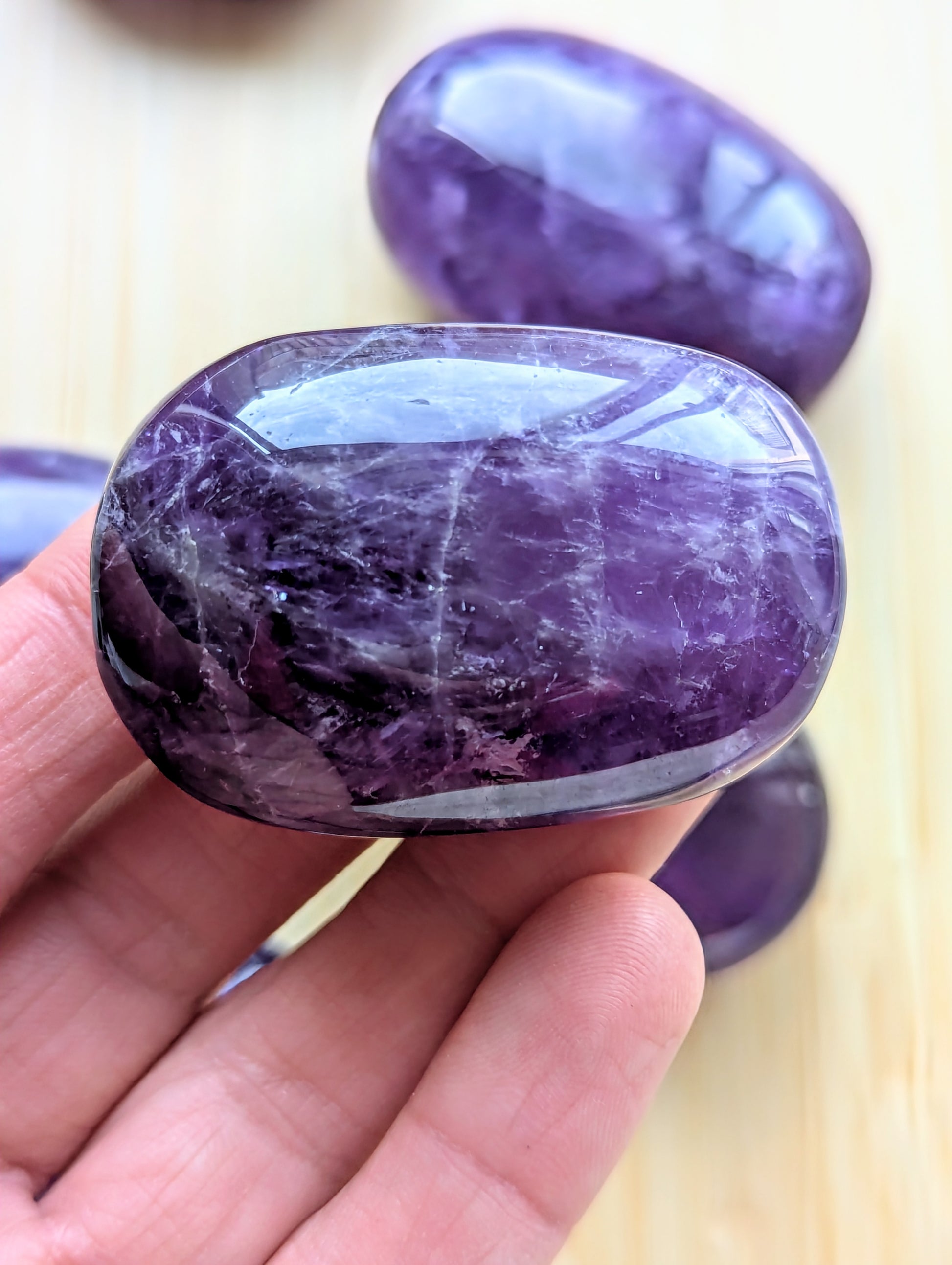 Purple stone held in a hand with a blurred background
