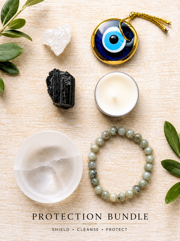 A flat-lay of a spiritual protection bundle on a light wood background, featuring a blue and gold evil eye pendant, a white salt shield, a black crystal, a green jade bracelet, a white candle, and crystals, with text reading 'PROTECTION BUNDLE' at the bottom.